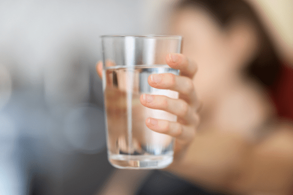 Image of woman holding glass of water