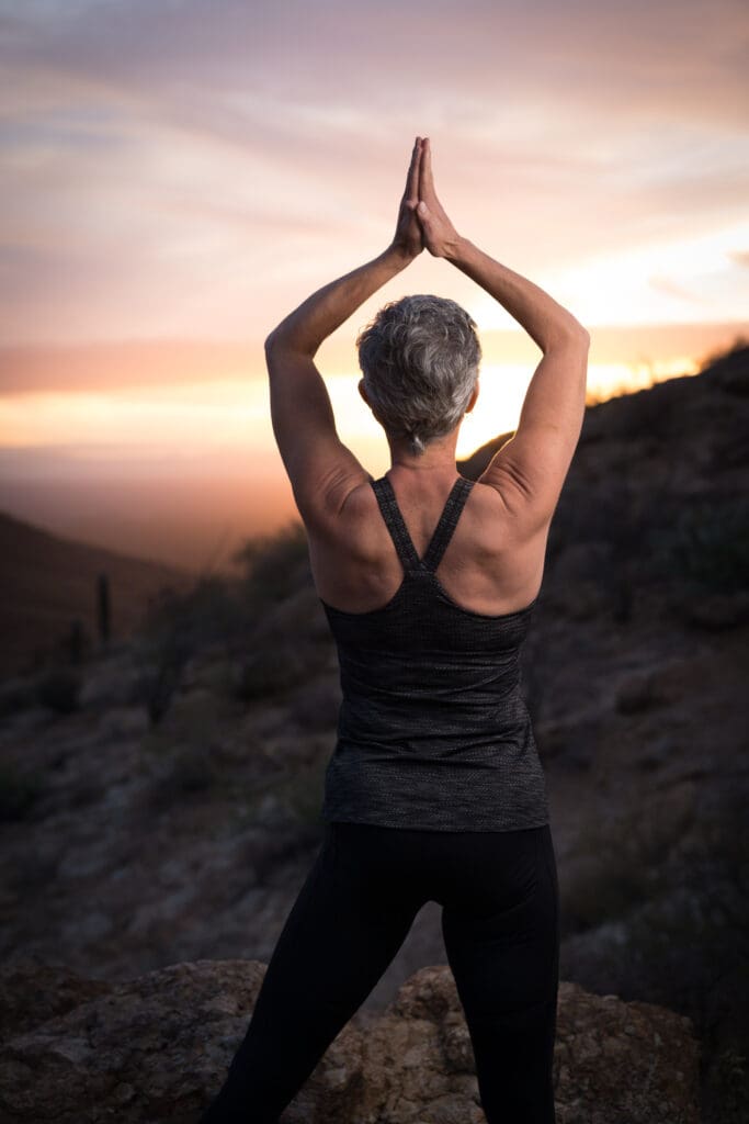 Woman in prayer looking at sunset