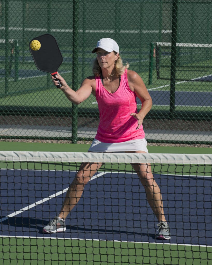 Female pickleball player hitting forehand