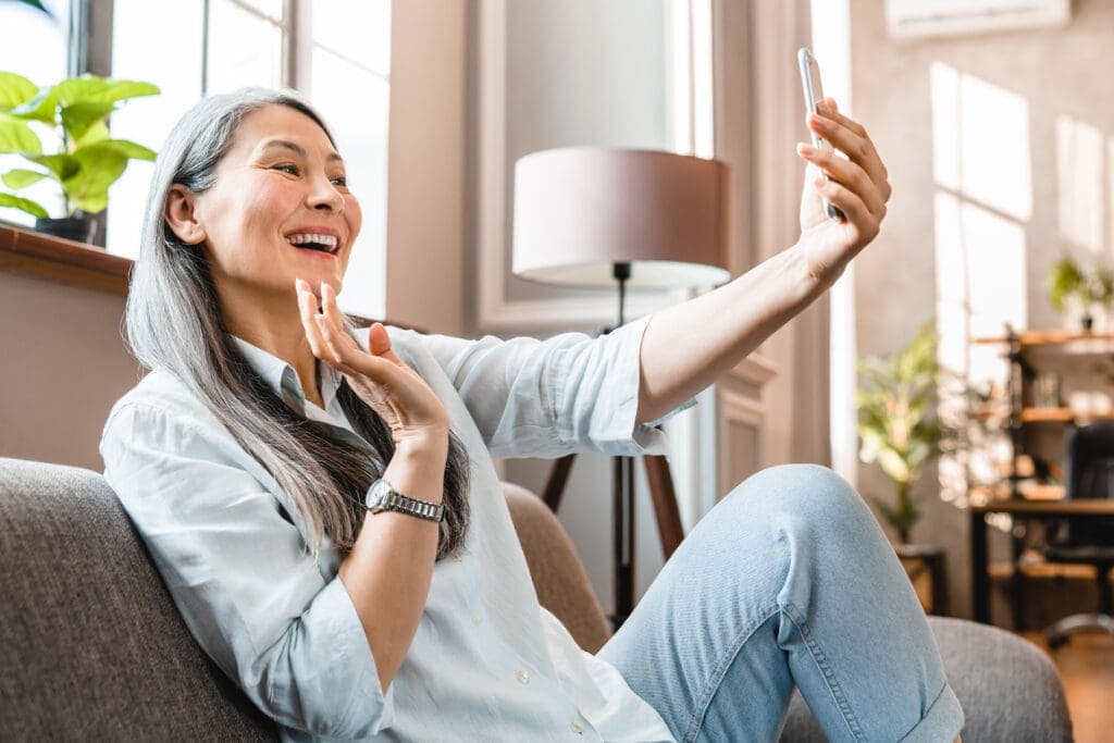 Asian woman with gray hair takes selfie