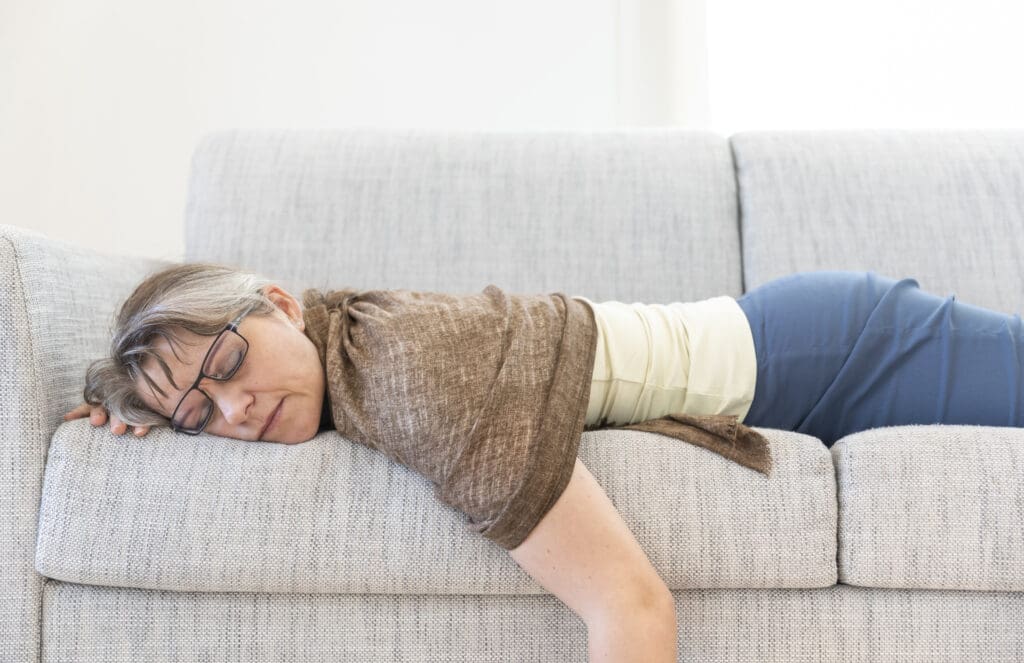 middle aged woman fallen asleep on couch