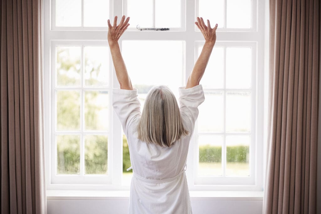 Woman morning stretch at the window