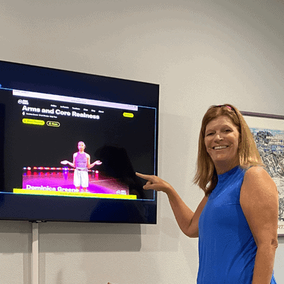 Woman stands in front of television pointing