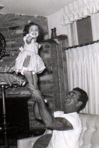 little girl is lifted up by her father