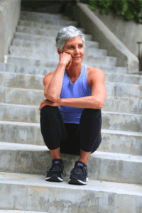 grey haired woman sitting on stairs