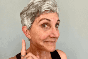 mature woman pointing to her hearing aids