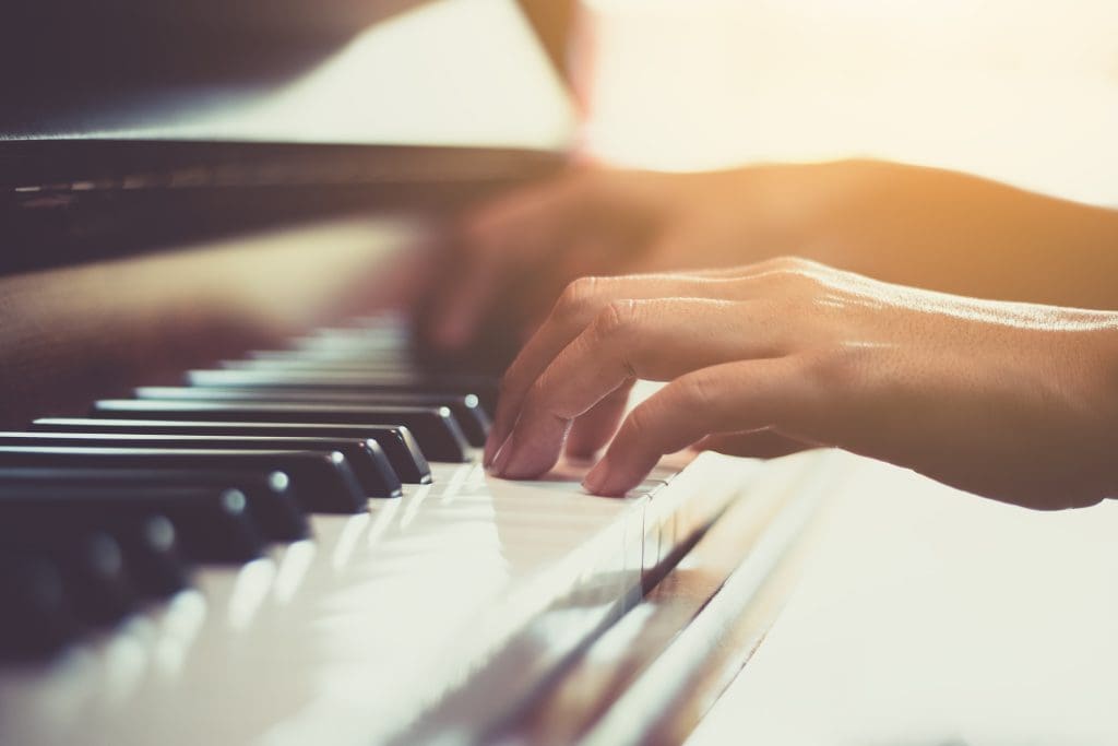 Close up of happy woman's hand playing the piano